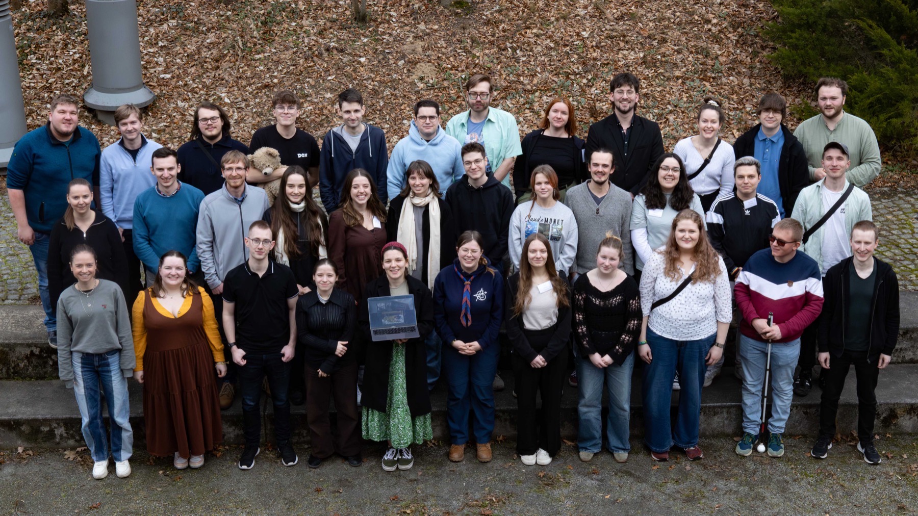Rund vierzig junge Menschen stehen für ein Gruppenfoto auf einer Freitreppe im Freien